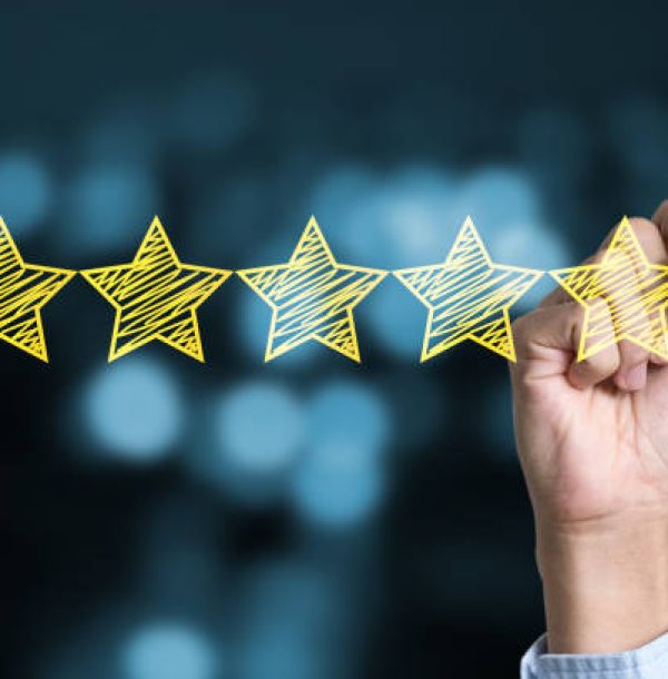 Businessman writing yellow five star to customer evaluation service and product. Marketing review and evaluation concept.